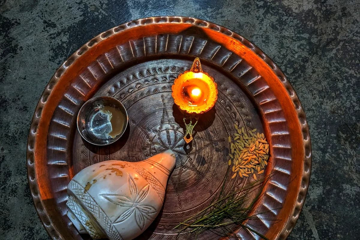 Auspicious brass thali with sacred roli, akshata, traditional sweets, and ghee diya for Bhai Dooj