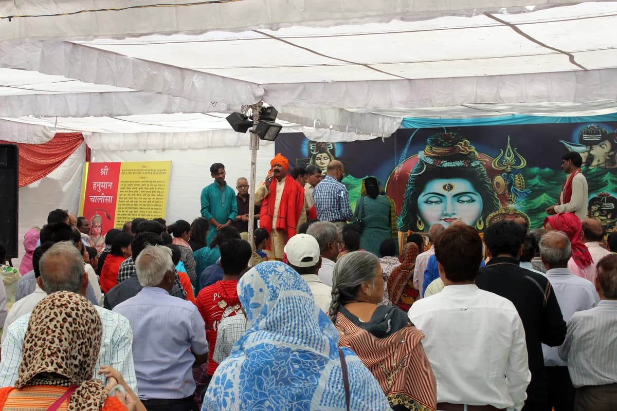 Devotees reciting sacred verses before the sindoor-anointed idol of Lord Hanuman