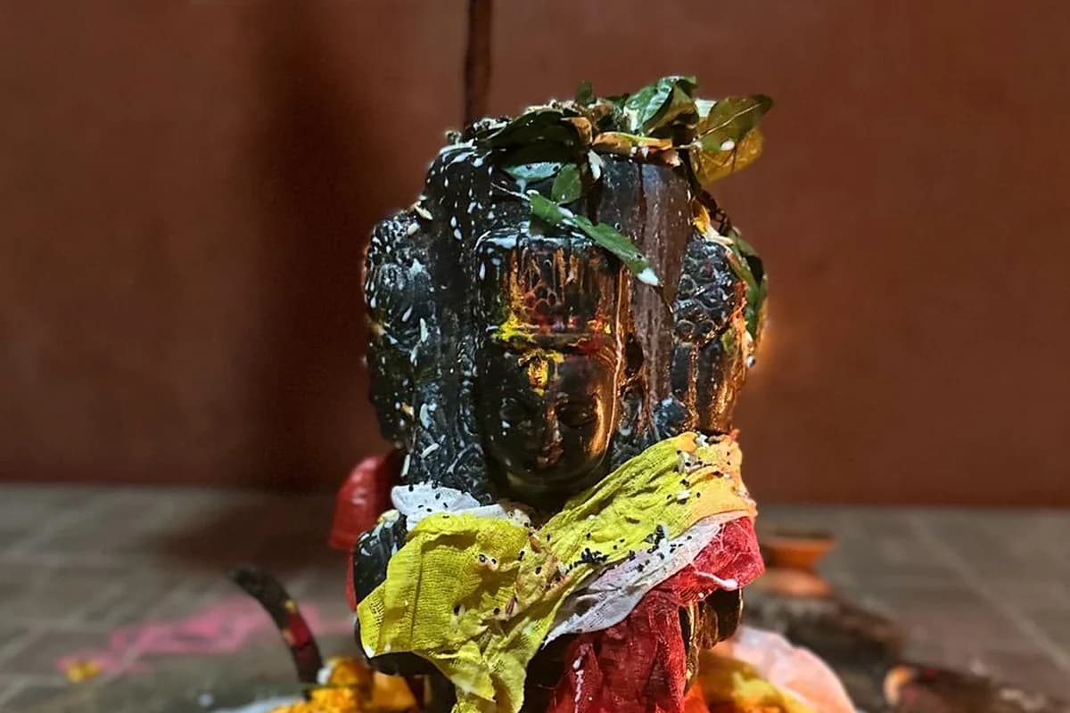 Sacred Shiva Lingam consecrated with holy water, vibhuti, bilva leaves, and datura flowers