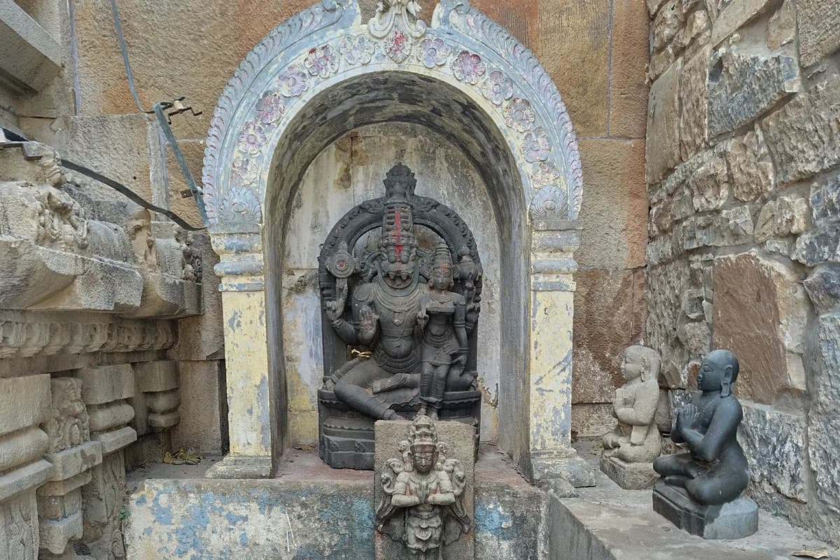 Sacred temple deity of Lord Narasimha with Goddess Lakshmi adorned in silk and floral garlands