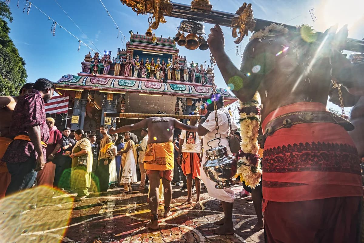 Devotees carrying sacred Kavadi and offering golden Vel to Lord Murugan during annual festival