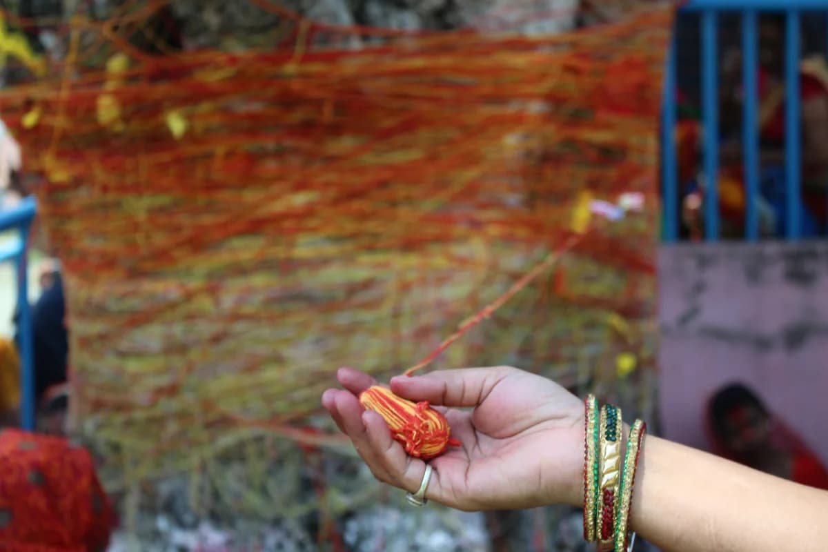 Married women winding sacred red-yellow thread around sprawling banyan tree trunk during Vat Savitri vrat